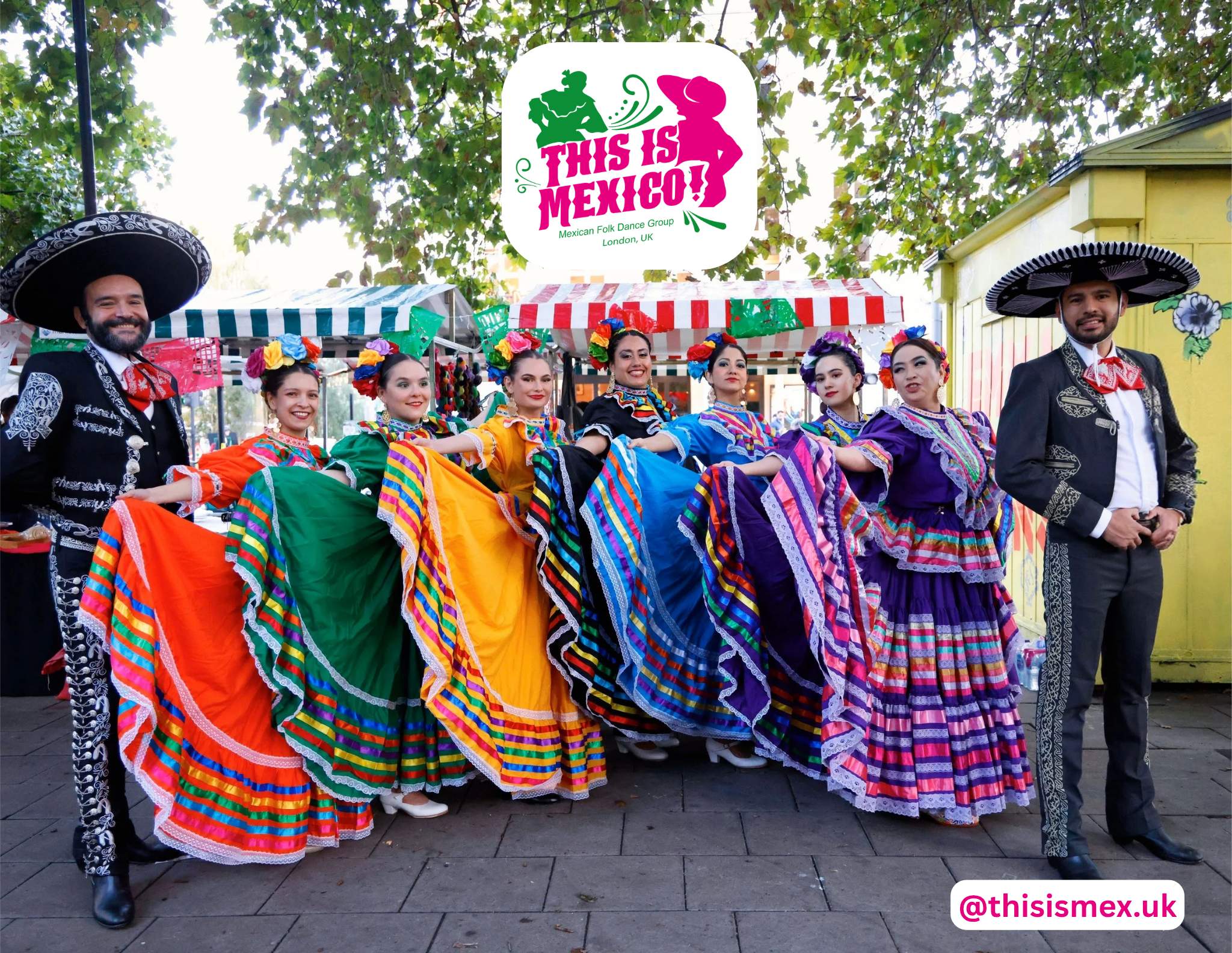 The company performing in the street at a Mexican market in London, flanked by two dancers in charro suits.