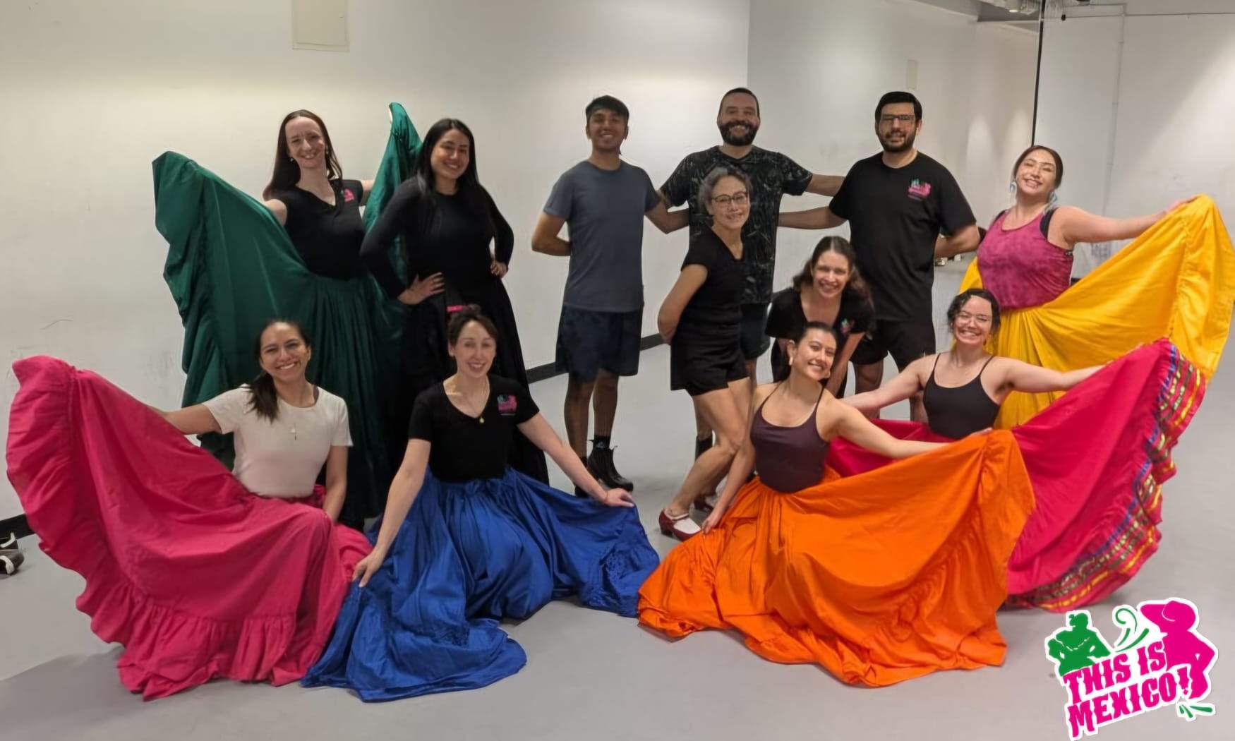 Members of the company at a rehearsal, holding out coloured practice skirts.